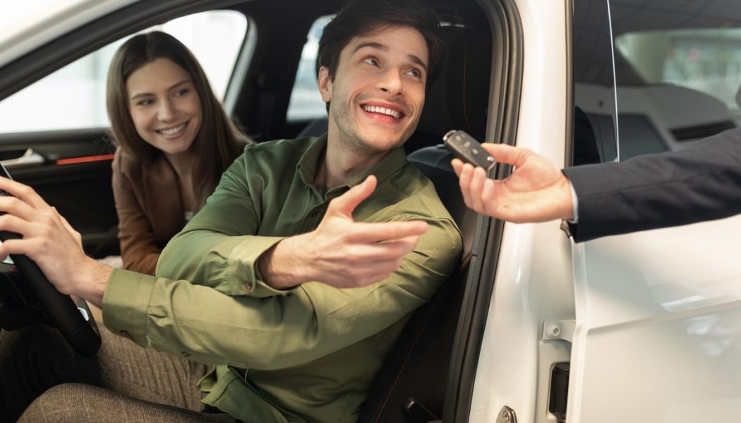 Happy,Millennial,Couple,Taking,Car,Key,From,Auto,Salesman,,Sitting