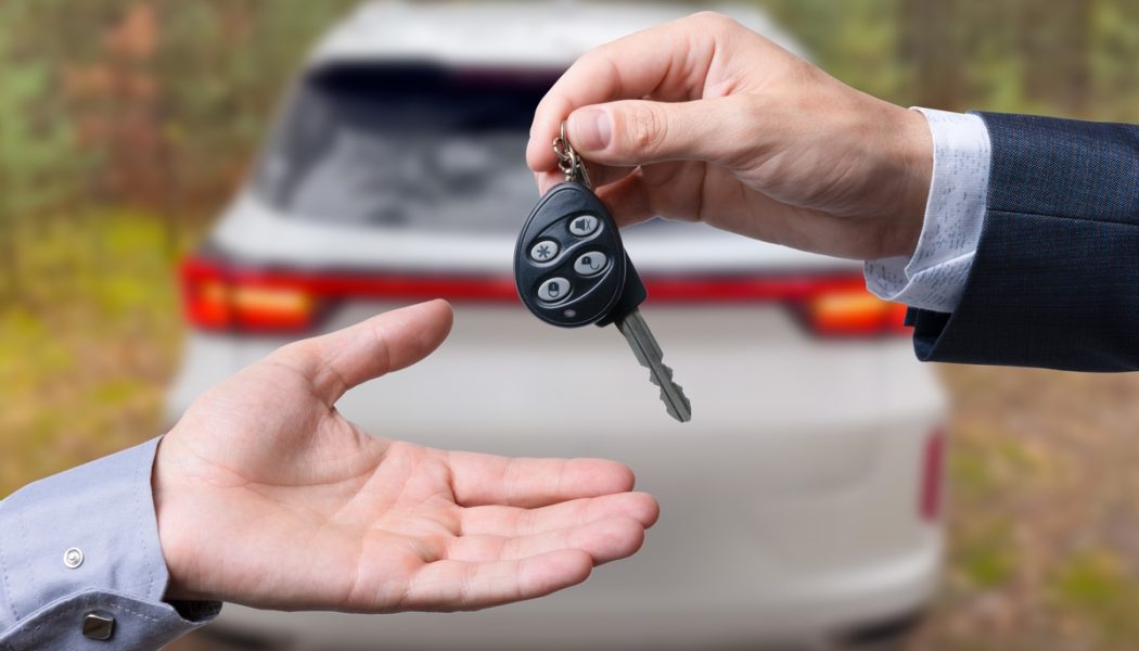 Close-up,Of,Dealer,Handing,Keys,To,New,Owners,At,A