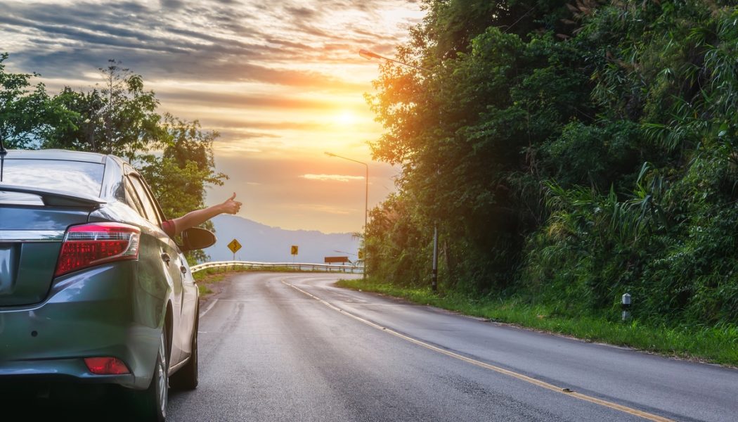 Thumbs-up,Gesture,From,A,Female,Traveler's,Hand,On,An,Asphalt